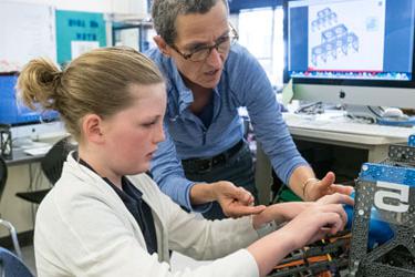 A teacher and student work on a project together in a classroom